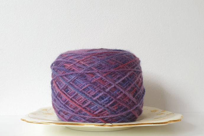 WILDBERRY OOAK 4PLY WOUND INTO A YARN CAKE SITTING ON A SAUCER